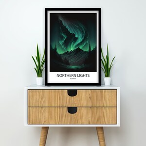 May include: A black framed poster with a green and blue illustration of the Northern Lights over a dark forest and lake. The poster has the text "NORTHERN LIGHTS" and "NORWAY" printed on it.