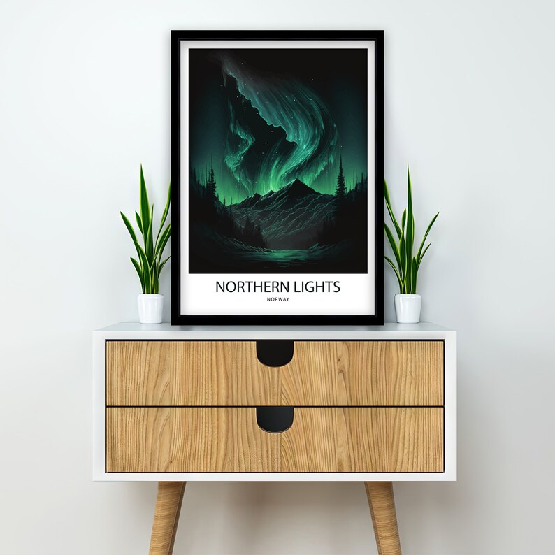 May include: A black framed poster with a green and blue illustration of the Northern Lights over a dark forest and lake. The poster has the text "NORTHERN LIGHTS" and "NORWAY" printed on it.