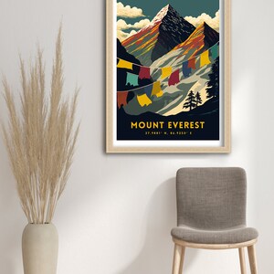 May include: A vintage travel poster design featuring a colorful illustration of Mount Everest with prayer flags hanging in the wind. The poster has a dark blue background with the text "MOUNT EVEREST 27.9881&deg; N, 86.9250&deg; E" in yellow.