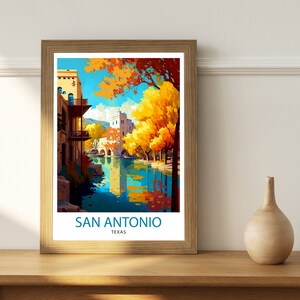 May include: A vintage travel poster featuring a scenic view of San Antonio, Texas. The poster depicts a river with a bridge and buildings along the banks. The trees are in autumn colors, with yellow, orange, and red leaves. The text "SAN ANTONIO TEXAS" is printed at the bottom of the poster.