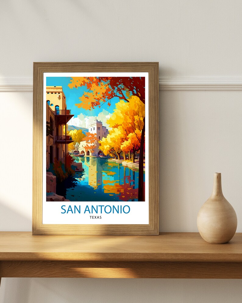 May include: A vintage travel poster featuring a scenic view of San Antonio, Texas. The poster depicts a river with a bridge and buildings along the banks. The trees are in autumn colors, with yellow, orange, and red leaves. The text "SAN ANTONIO TEXAS" is printed at the bottom of the poster.