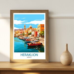 May include: A framed poster with a colorful illustration of a harbor scene in Heraklion, Greece. The poster features a row of colorful boats docked in a harbor with buildings in the background. The text "HERAKLION GREECE" is printed at the bottom of the poster.