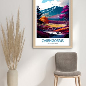 K&ouml;nnte beinhalten: Eine farbenfrohe Illustration einer Bergkette mit einem Fluss, der durch sie flie&szlig;t. Der Text "CAIRNGORMS NATIONAL PARK" befindet sich am unteren Rand des Bildes.