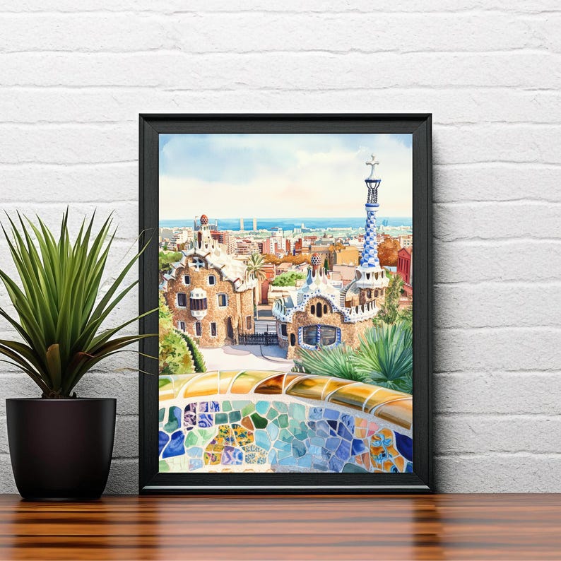 May include: Framed watercolor print of Park G&uuml;ell in Barcelona, Spain. The artwork depicts the park's architecture, including the iconic mosaic benches and the colorful, patterned tower. The scene is set against a backdrop of a blue sky and the city.
