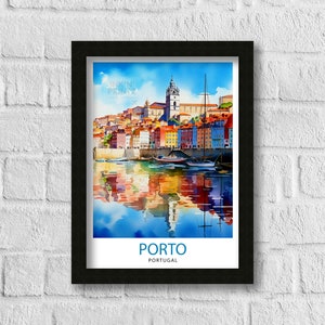 May include: A watercolor painting of the city of Porto, Portugal. The painting shows colorful buildings along the Douro River with boats in the water. The painting is framed in black.