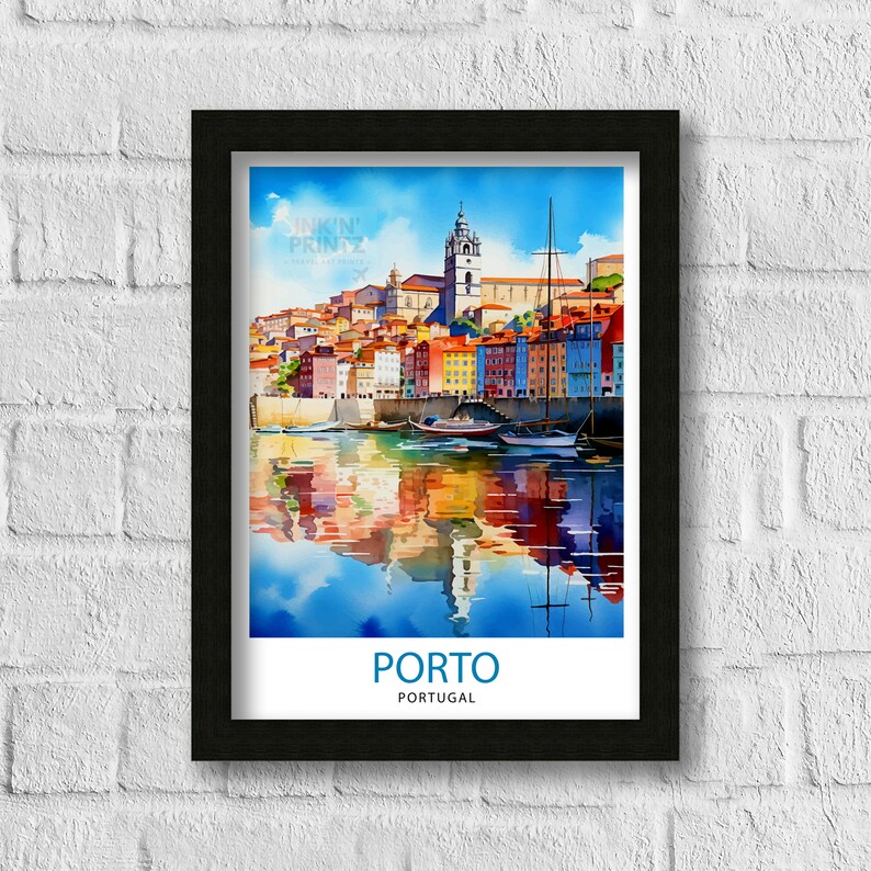May include: A watercolor painting of the city of Porto, Portugal. The painting shows colorful buildings along the Douro River with boats in the water. The painting is framed in black.