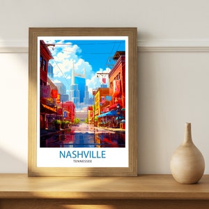 May include: A framed print of a colorful illustration of a street scene in Nashville, Tennessee. The print features a tall building in the background and a street lined with shops and buildings. The text "NASHVILLE" and "TENNESSEE" is printed below the image.