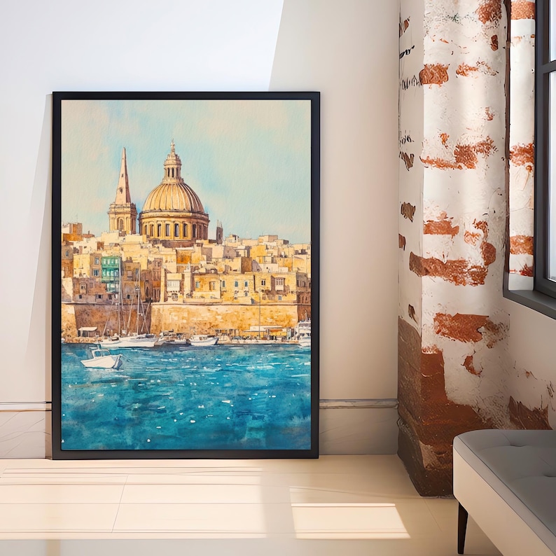 May include: A framed watercolor painting depicts a coastal city with a large domed structure and a tall spire. The artwork features a vibrant blue sea and a light blue sky, with boats in the water. The buildings are painted in shades of yellow and beige.