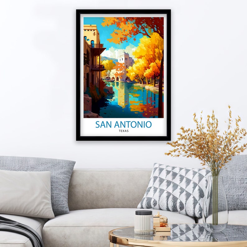 May include: A vintage travel poster featuring a colorful illustration of a river scene in San Antonio, Texas. The poster has a black frame and features a cityscape with buildings and trees reflected in the water.