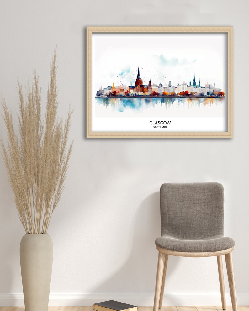 May include: A watercolor painting of the Glasgow skyline, featuring the city's iconic buildings and a reflection in the water. The painting is framed in a light wood frame and is titled "GLASGOW, SCOTLAND".