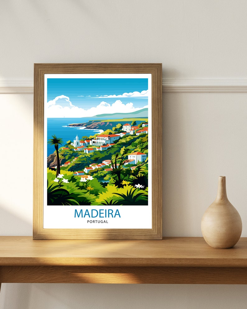 May include: A framed poster featuring a colourful illustration of a coastal town in Madeira, Portugal. The poster depicts a blue sky with white clouds, a blue ocean, green hills, and white buildings. The text "MADEIRA PORTUGAL" is printed at the bottom of the poster.
