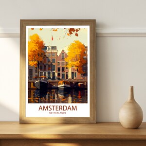 May include: A vintage travel poster with a colorful illustration of Amsterdam, Netherlands. The poster features a canal with boats and traditional Dutch houses with yellow trees in the foreground. The text "AMSTERDAM" and "NETHERLANDS" is printed in red at the bottom of the poster.