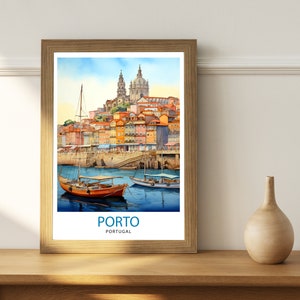 Op de afbeelding: Een ingelijst aquarel schilderij van de stad Porto, Portugal. De schildering toont een stadsbeeld met kleurrijke gebouwen, een kerk en boten in het water. De tekst "PORTO" en "PORTUGAL" is onder de afbeelding gedrukt.