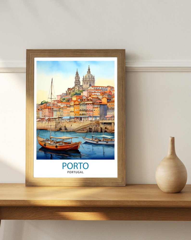 Op de afbeelding: Een ingelijst aquarel schilderij van de stad Porto, Portugal. De schildering toont een stadsbeeld met kleurrijke gebouwen, een kerk en boten in het water. De tekst "PORTO" en "PORTUGAL" is onder de afbeelding gedrukt.
