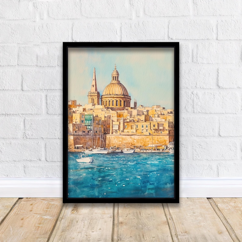 May include: Watercolor painting of a coastal city with a large domed building and a tall spire. The buildings are a warm yellow and orange, with a blue sea and sky. Several boats are in the water. The artwork is framed in a black frame.