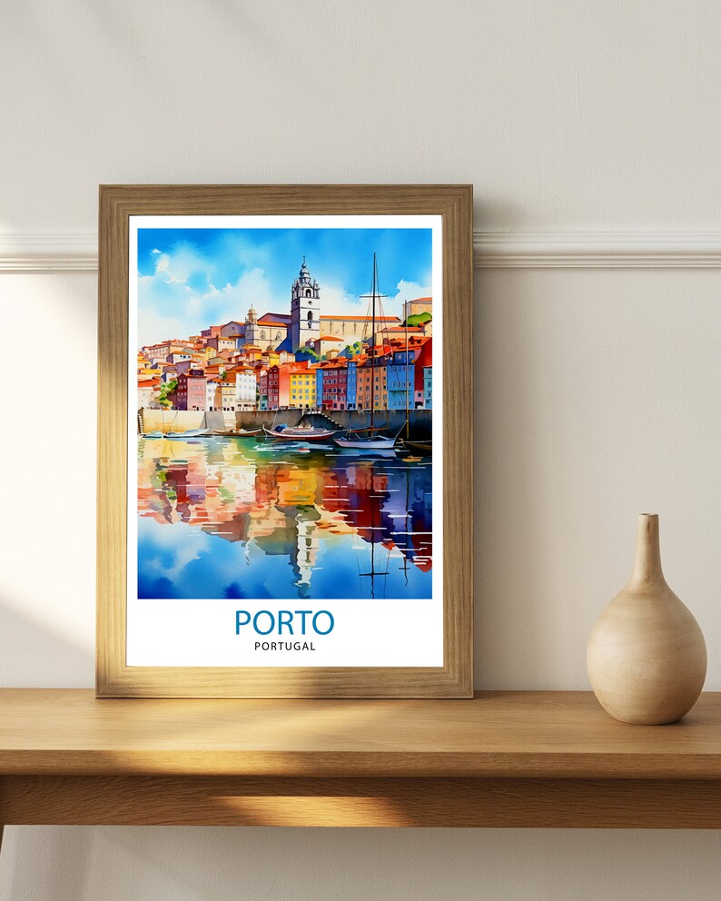 May include: A watercolor painting of the city of Porto, Portugal. The painting shows colorful buildings lining the waterfront with boats docked in the harbor. The water reflects the buildings and sky. The text "PORTO" and "PORTUGAL" is printed below the image.