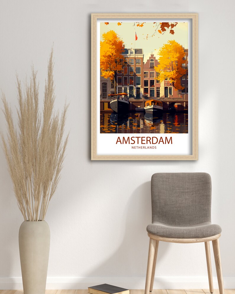 May include: A vintage travel poster featuring a colorful illustration of Amsterdam, Netherlands. The poster depicts a canal with boats and buildings lined with trees with yellow leaves. The text "AMSTERDAM" and "NETHERLANDS" is printed in red at the bottom of the poster.