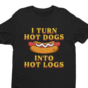 Peut inclure: T-shirt noir avec un graphique jaune et orange d'un hot-dog et le texte "I turn hot dogs into hot logs".