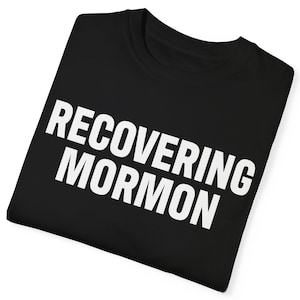 May include: Black t-shirt with white text that reads "RECOVERING MORMON".