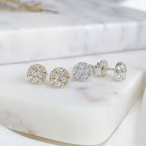 May include: A pair of small, round diamond earrings. One pair is set in gold and the other in silver.