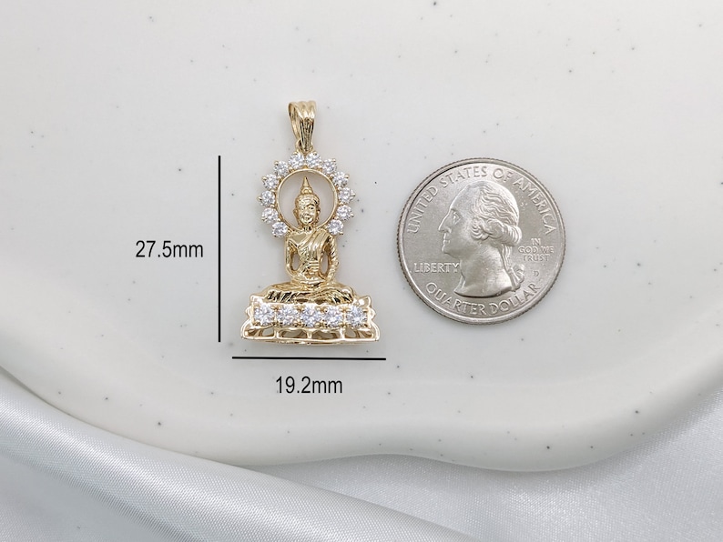 K&ouml;nnte beinhalten: Goldfarbener Anh&auml;nger mit einer sitzenden Buddha-Figur mit einem Heiligenschein aus klaren Zirkonia-Steinen. Der Anh&auml;nger ist 27,5 mm hoch und 19,2 mm breit.
