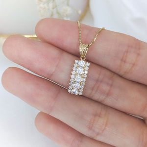 Puede incluir: Un collar de oro con un colgante rectangular engastado con peque&ntilde;as piedras de circonita c&uacute;bica transparentes.