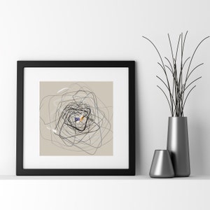 May include: Black framed abstract art print with a beige background and black, gray, and blue lines forming a swirling pattern. The lines are centered in the middle of the print and create a circular shape.