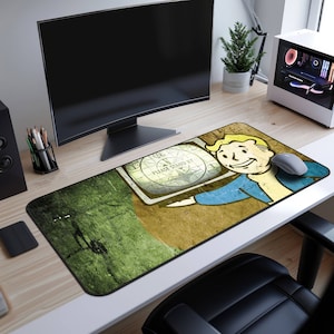 May include: A green, yellow, and brown gaming mouse pad with a retro-style illustration of a cartoon character holding a television screen with the text "Please Stand By".