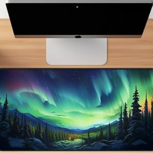 May include: A black mouse pad with a colorful aurora borealis scene over a dark forest. The aurora is green, blue, and purple with a starry night sky.