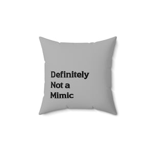 May include: A square, light gray pillow with the text "Definitely Not a Mimic" printed in black. The pillow is a solid color with a simple, modern design, suitable for home decor.