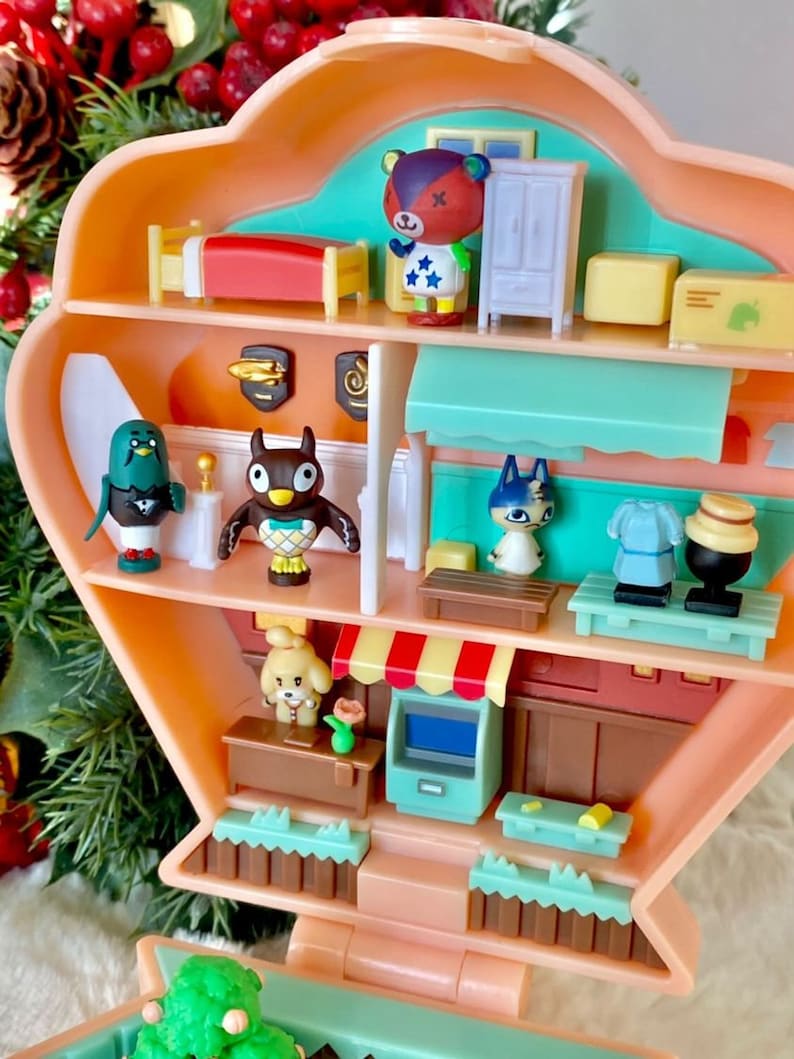 May include: A multi-level pink and green plastic toy house with a variety of animal characters and furniture. The house is open and the interior is visible. The characters include a bear, an owl, a cat, a bird, and a dog. The furniture includes a bed, a dresser, a table, and a chair.