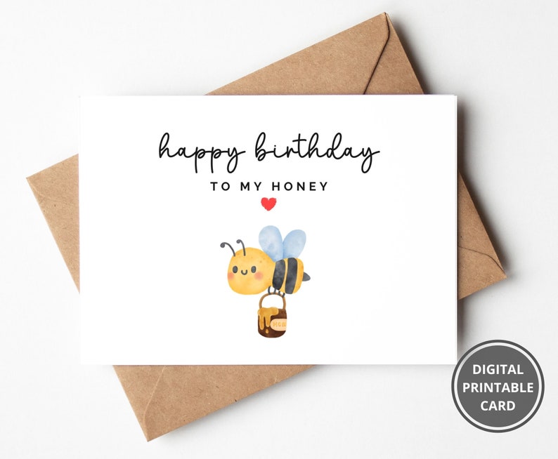 May include: A white card with the text "happy birthday to my honey" and a cartoon bee carrying a pot of honey. A red heart is above the word "honey".
