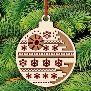 K&ouml;nnte beinhalten: Weihnachtsbaumschmuck aus Holz mit rotem Band. Der Schmuck ist hellbraun mit einem braunen Design mit Schneeflocken und einem kreisf&ouml;rmigen Design. Der Schmuck h&auml;ngt vor einem gr&uuml;nen Weihnachtsbaum.