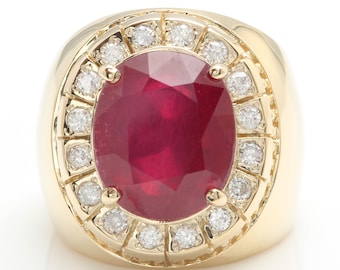 May include: A gold ring with a large oval ruby surrounded by a halo of smaller diamonds.