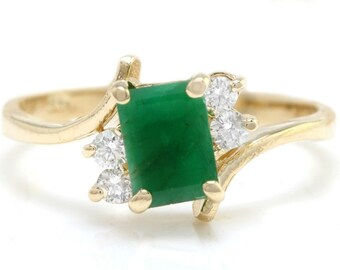 May include: A gold ring with a large emerald green gemstone and smaller diamond accents.