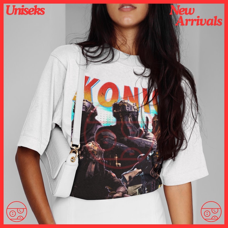 May include: White t-shirt with a graphic print of a band called "KONK" in a retro style. The graphic features a group of people in a futuristic setting.