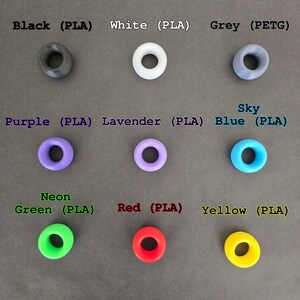 May include: Assortment of 10 colorful plastic rings in various colors, including black, white, grey, purple, lavender, sky blue, neon green, red, and yellow. The rings are made of PLA and PETG plastic.