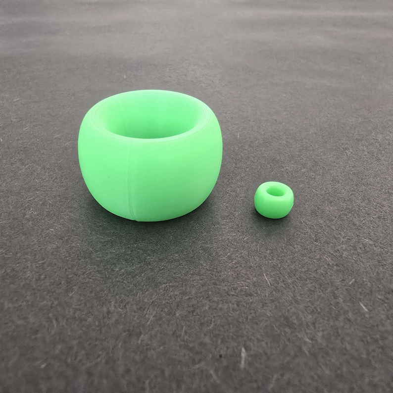 May include: Two green silicone rings, one larger and one smaller. The larger ring is shaped like a bowl.