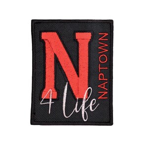 May include: Black rectangular patch with a large red "N" and the words "Naptown" and "4 Life" in white script. The patch is likely an embroidered emblem, suitable for application on clothing or accessories.