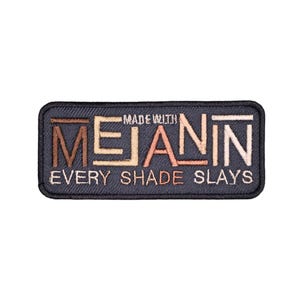 May include: A black embroidered patch with the text "Made with Melanin Every Shade Slays" in various shades of brown, peach, and beige.