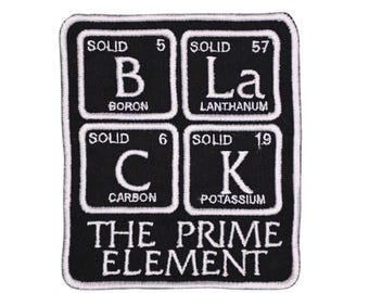 Puede incluir: Un parche bordado rectangular de color negro con cuatro cuadrados blancos estilo tabla periódica para Boro, Lantano, Carbono y Potasio, que deletrean BLACK. Debajo de los cuadrados, el texto THE PRIME ELEMENT aparece en letras blancas.