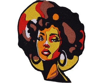 Puede incluir: Parche bordado con un retrato estilizado de una mujer con afro. El diseño utiliza una paleta de negro, amarillo, naranja, rojo y marrón. La mujer lleva pendientes de aro grandes. El parche es probablemente para ropa o accesorios.