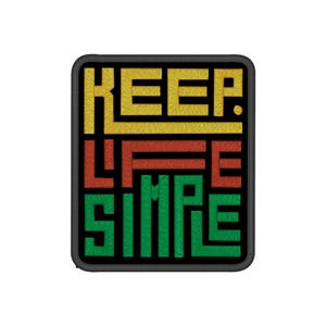 Op de afbeelding: Geborduurde patch met de tekst "KEEP LIFE SIMPLE" in gele, rode en groene blokletters. De patch heeft een zwarte rand en een rechthoekige vorm met afgeronde hoeken. De tekst is gecentreerd op een witte achtergrond.