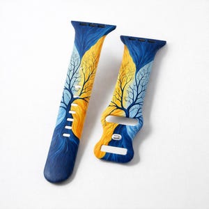 May include: Two blue and yellow Apple Watch bands with a painted tree design. The bands feature a dark blue base that transitions into a yellow and light blue tree design. The bands are made of a flexible material.