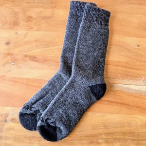 May include: A pair of gray wool socks with black heels and toes.