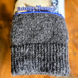 May include: A pair of dark gray thermal socks with the words "Extreme Thermal" printed on the packaging.