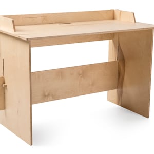 May include: A light wood desk with a simple design. The desk has a flat top and a single shelf underneath. The desk is made of plywood and has a natural wood finish.