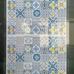 Pu&ograve; includere: Un foglio di carta decorativa con un motivo ripetuto di piastrelle blu e gialle. Le piastrelle presentano vari disegni geometrici e un motivo di limone.
