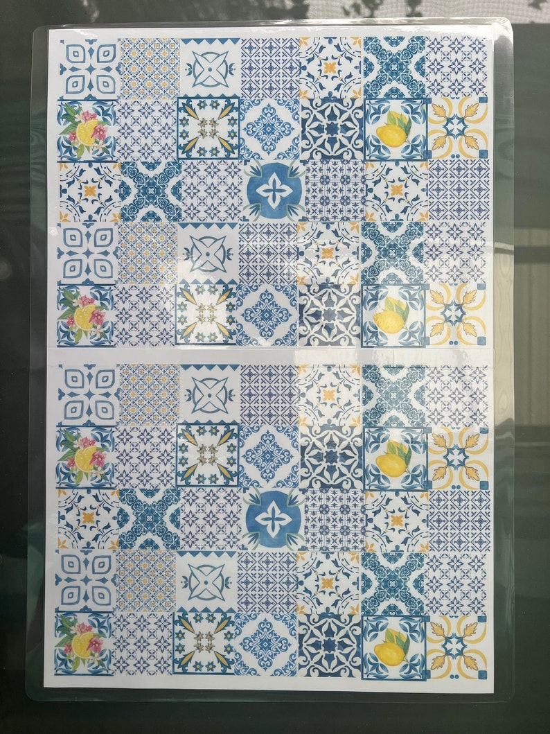 Pu&ograve; includere: Un foglio di carta decorativa con un motivo ripetuto di piastrelle blu e gialle. Le piastrelle presentano vari disegni geometrici e un motivo di limone.