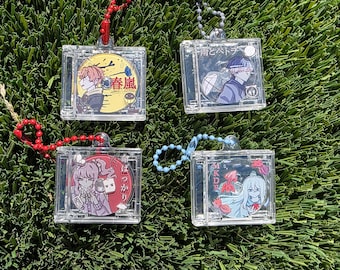 May include: Four clear plastic keychains with colorful anime character illustrations and Japanese text. Each keychain features a different character and design.